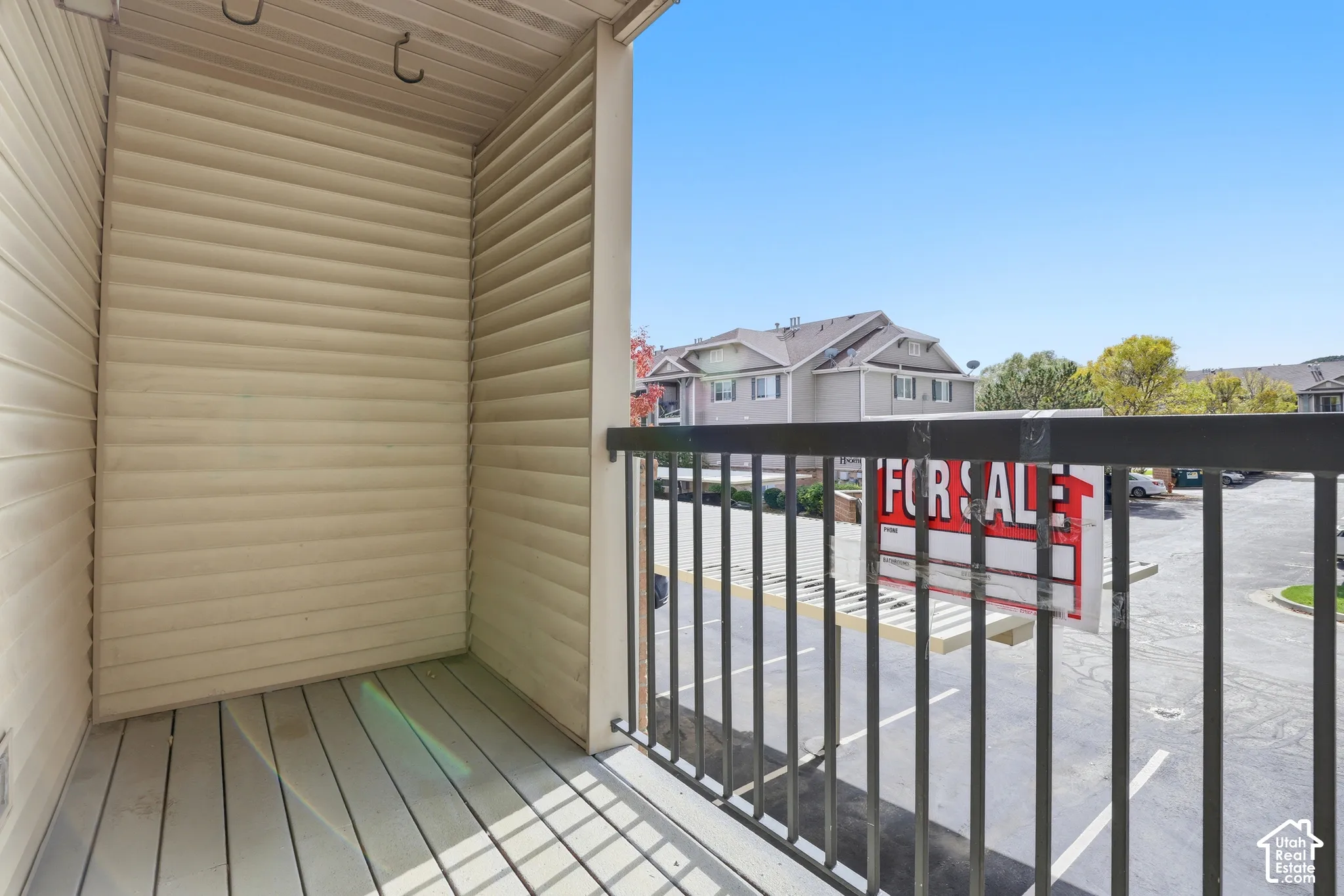 Covered balcony featuring horizontal vinyl siding, metal railing, and wood-slat flooring