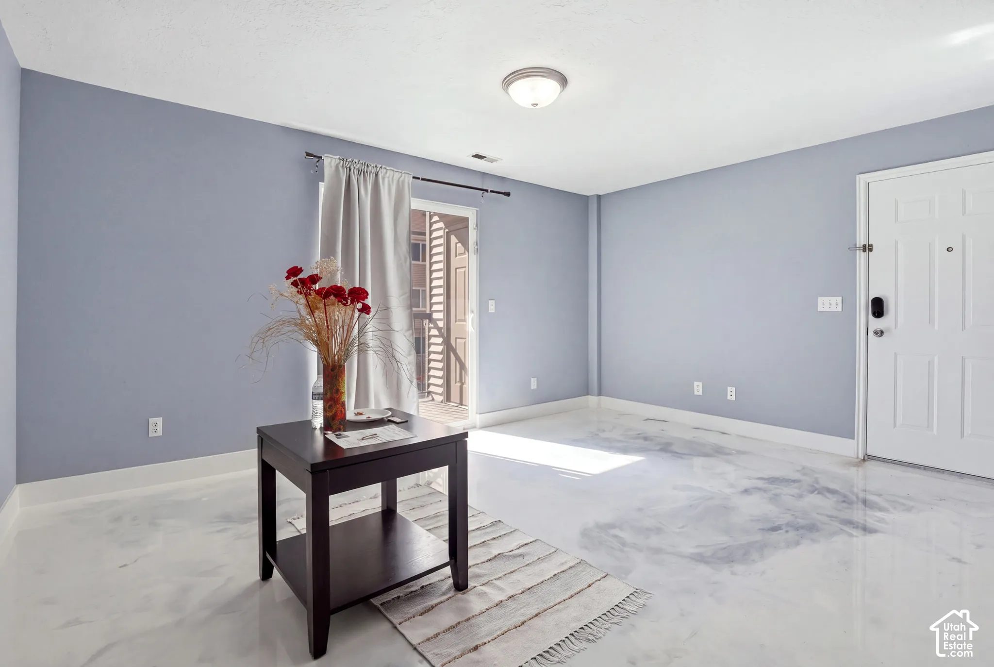Interior space featuring high-gloss marbled flooring, flush-mount ceiling lighting, and a glass-paneled entry door