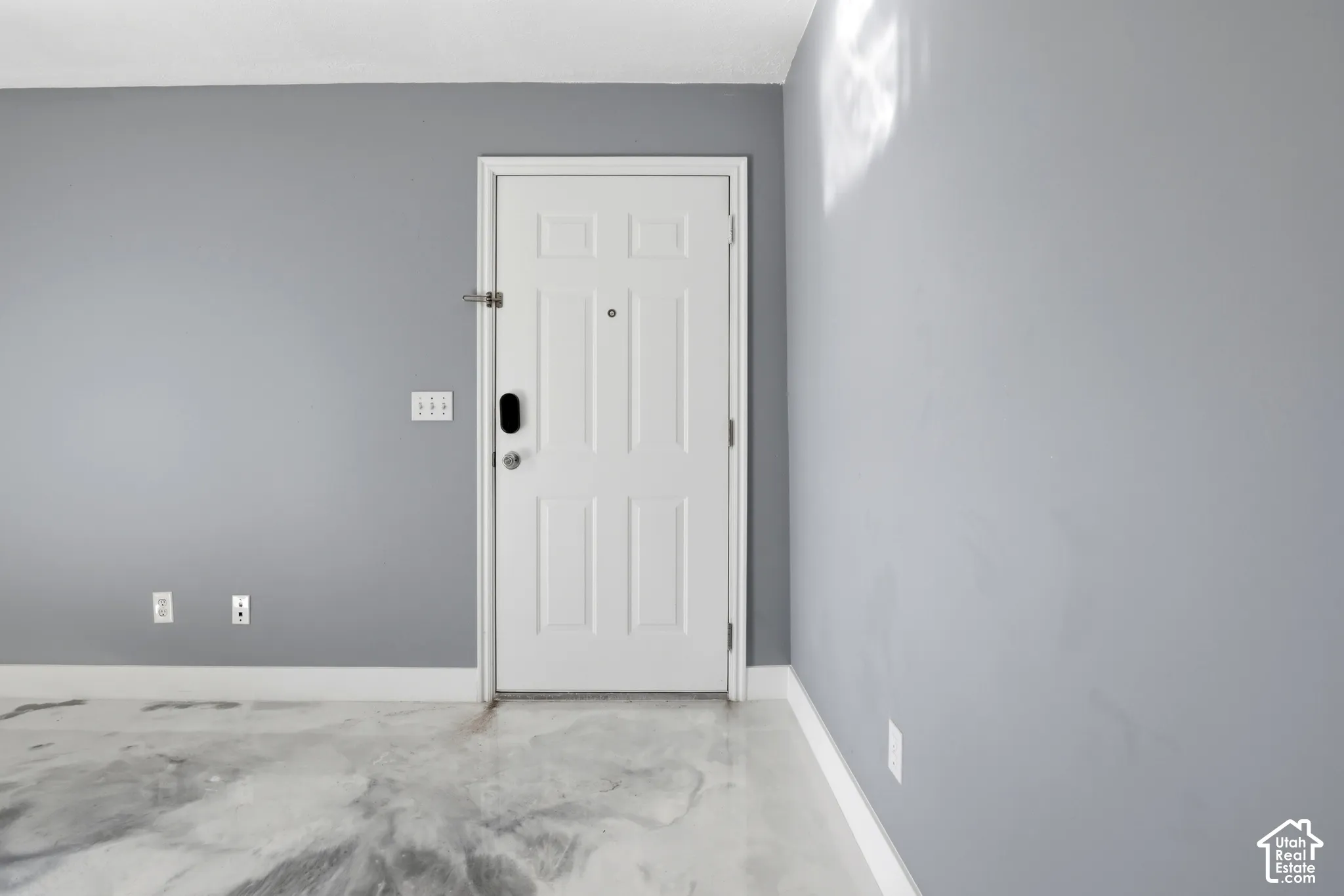 White six-panel interior door with integrated electronic lock, set against neutral gray wall surfaces and polished marbled-finish flooring