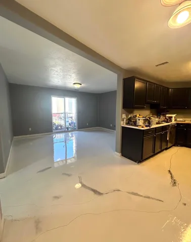 Kitchen with light countertops, open floor plan, and dark cabinetry