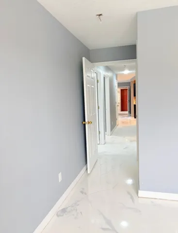 Corridor with baseboards and light marble finish flooring