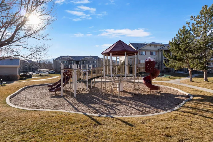 Communal playground with a yard and a residential view