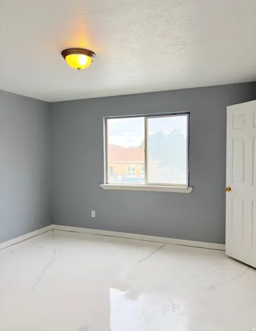 Unfurnished room with baseboards and a textured ceiling