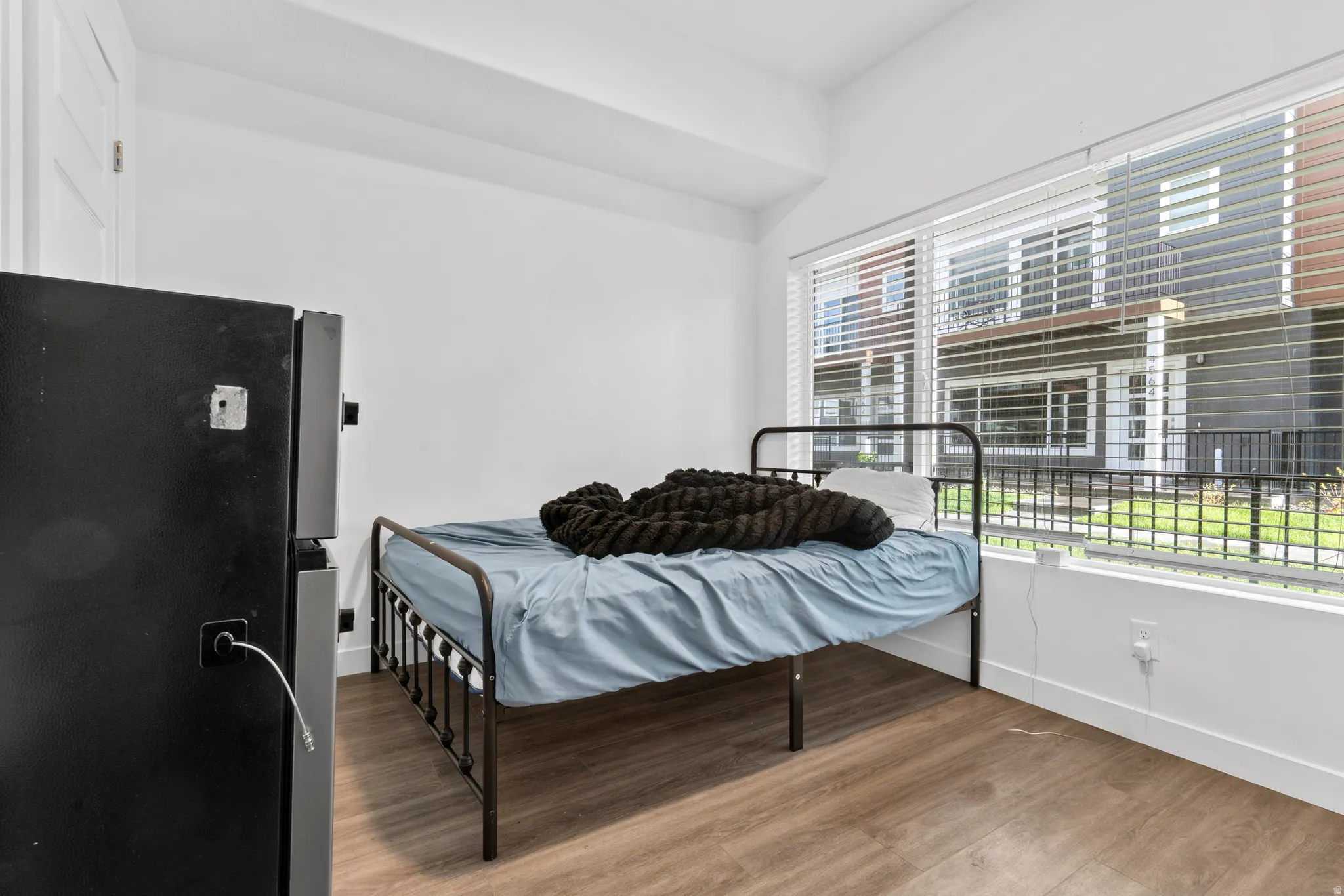 Bedroom featuring light wood-type flooring and freestanding refrigerator