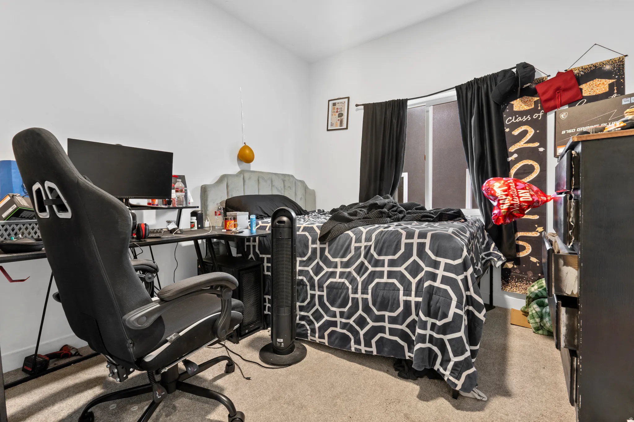 Bedroom with light colored carpet and an office area