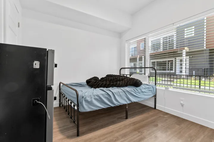 Bedroom featuring light wood-type flooring and freestanding refrigerator