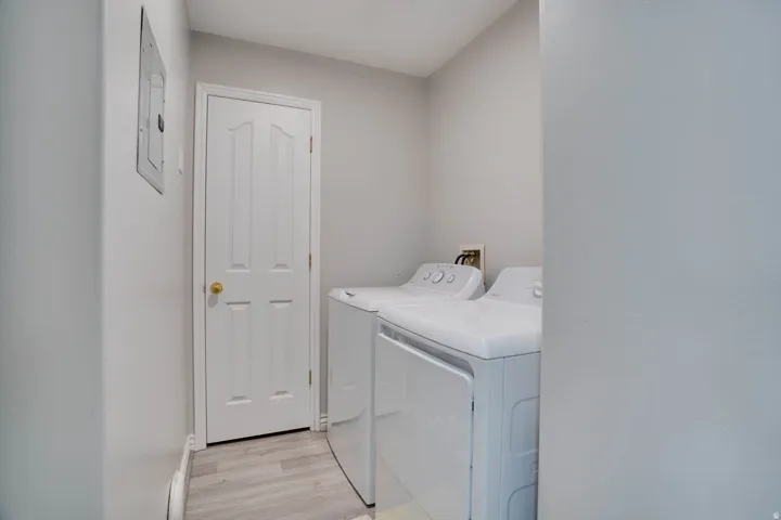Laundry room featuring light wood-style flooring and independent washer and dryer