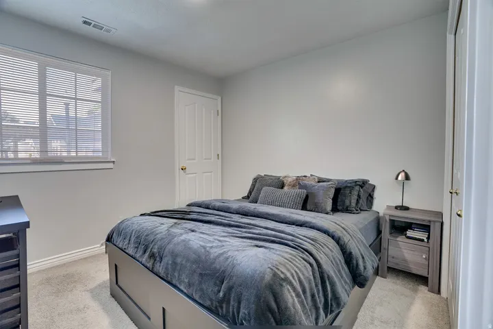 Bedroom featuring light carpet and baseboards