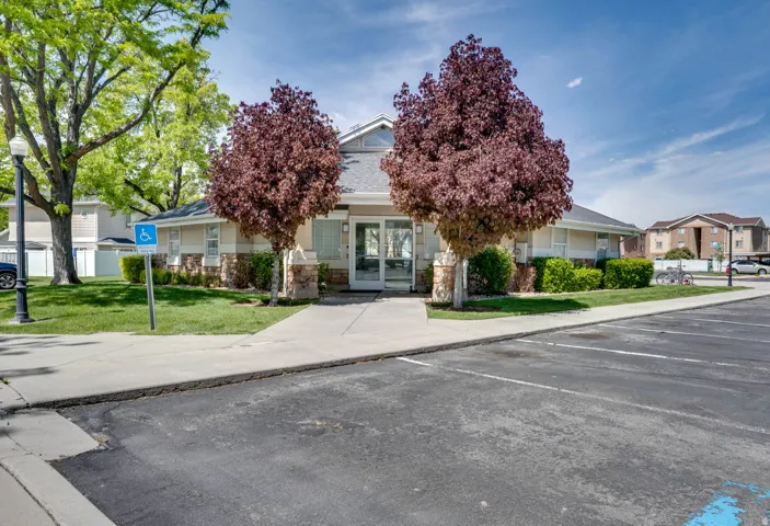 View of front of property featuring a front yard, french doors, stone siding, uncovered parking, and a residential view