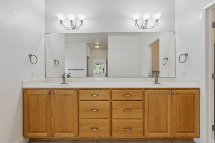 Bathroom with suspended lighting, double vanity, and light tile patterned floors