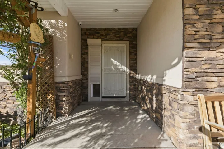 Entrance to property with stone siding and stucco siding