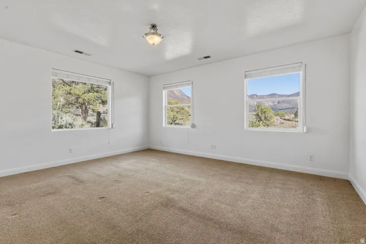 Carpeted empty room with baseboards