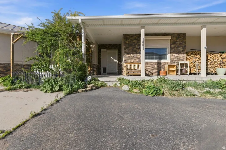View of exterior entry featuring a porch and stone siding