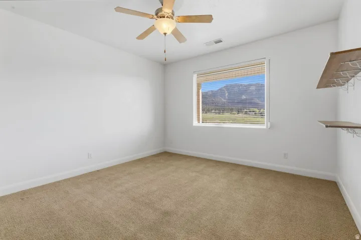 Unfurnished room with light carpet and a ceiling fan
