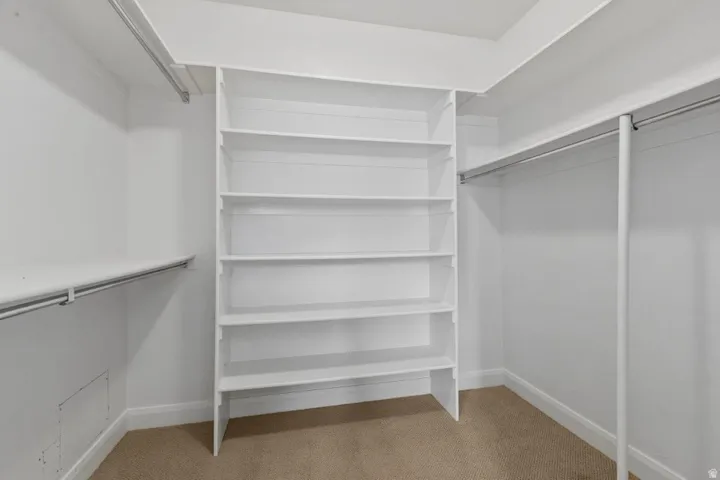 Walk in closet featuring light carpet