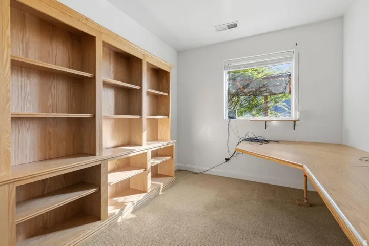 Unfurnished office featuring light colored carpet and baseboards