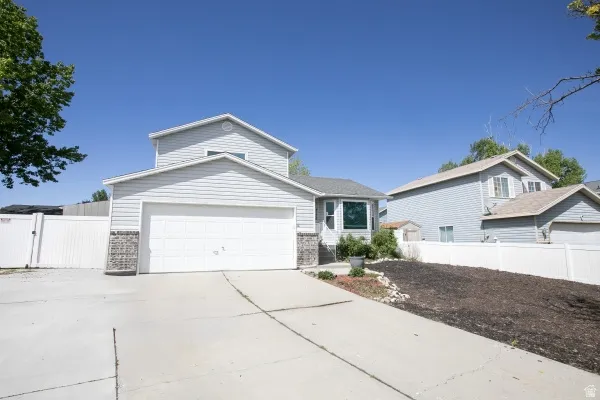 Traditional home with a gate, driveway, and a garage