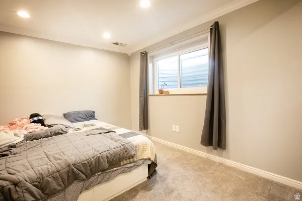 Bedroom featuring ornamental molding, light colored carpet, and recessed lighting