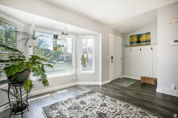 Foyer with dark wood-style flooring and lofted ceiling