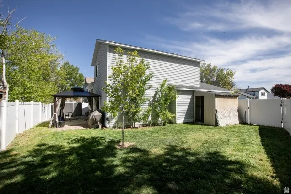 Back of property featuring a gate, a fenced backyard, a patio area, and a gazebo