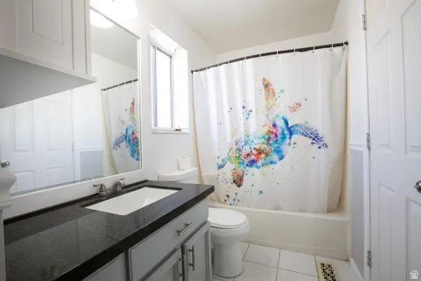 Bathroom featuring vanity, light tile patterned flooring, and shower / bath combo with shower curtain