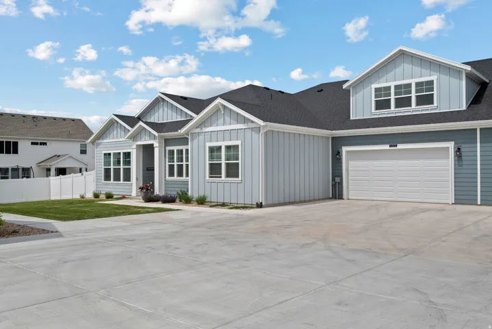 View of front of house featuring board and batten siding, concrete driveway, a shingled roof, and a garage