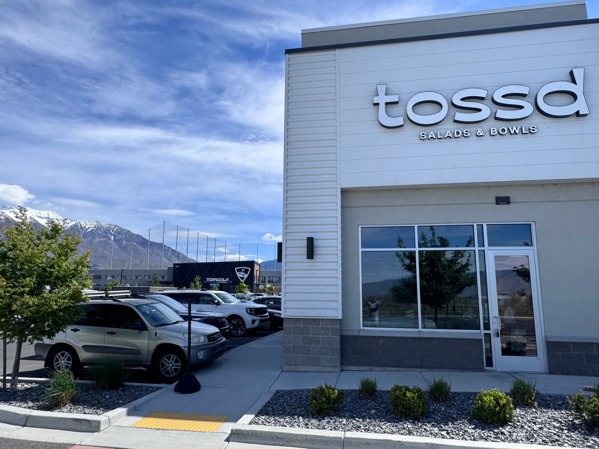 View of building exterior featuring a mountain view and uncovered parking