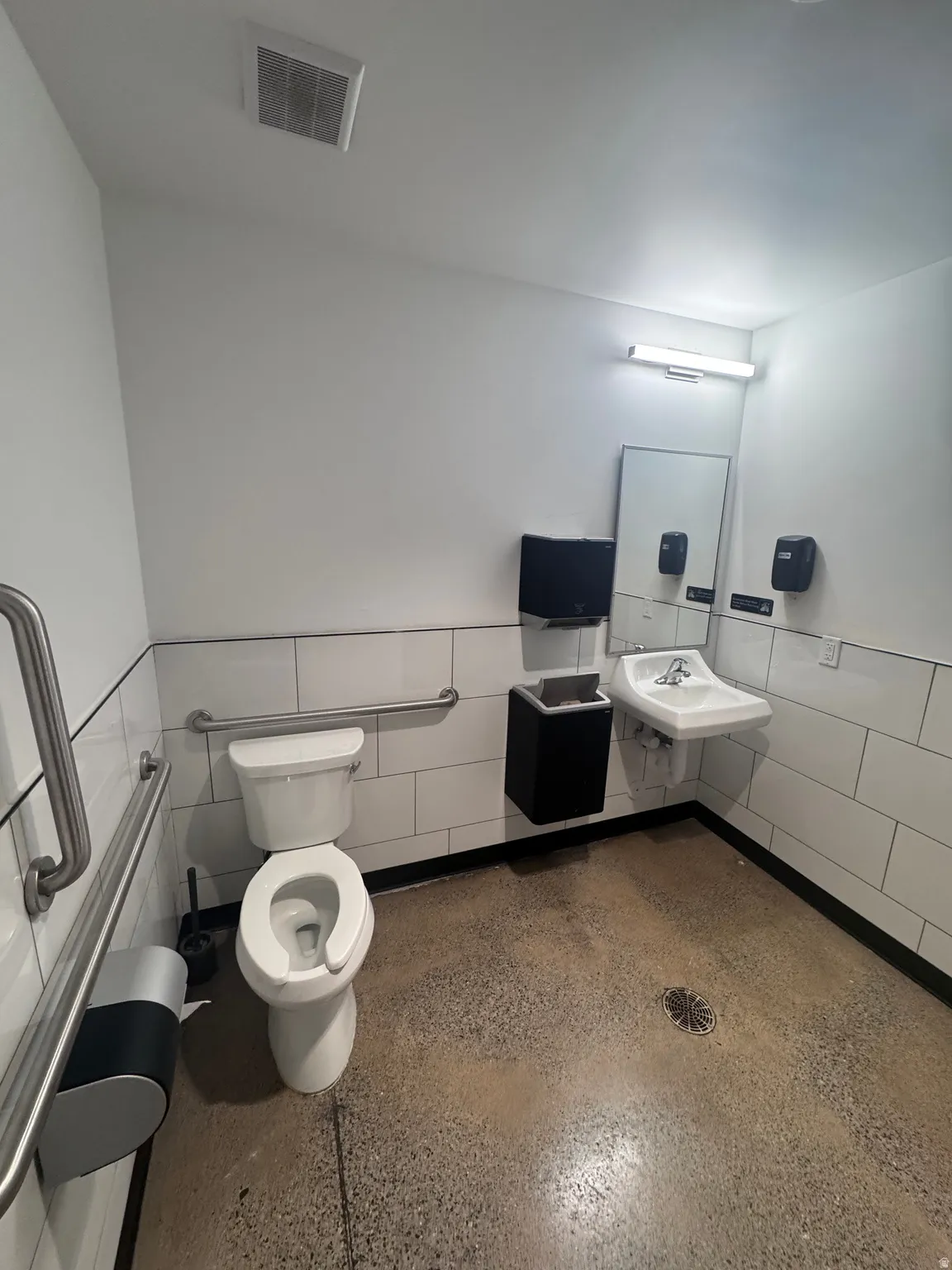 Bathroom featuring a wainscoted wall and tile walls
