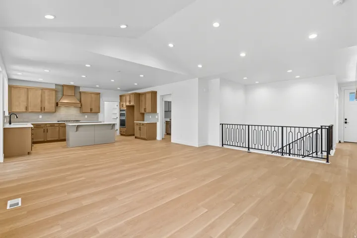 Unfurnished living room featuring recessed lighting, light wood finished floors, and vaulted ceiling