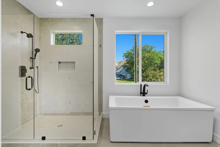 Full bath with a freestanding tub, a shower stall, recessed lighting, and light tile patterned floors