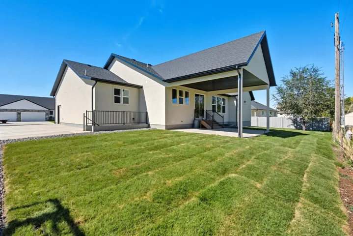 Rear view of property with a patio, a shingled roof, and stucco siding