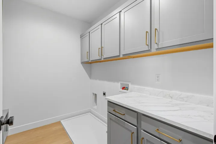Laundry room with washer hookup, light wood-style flooring, cabinet space, and electric dryer hookup
