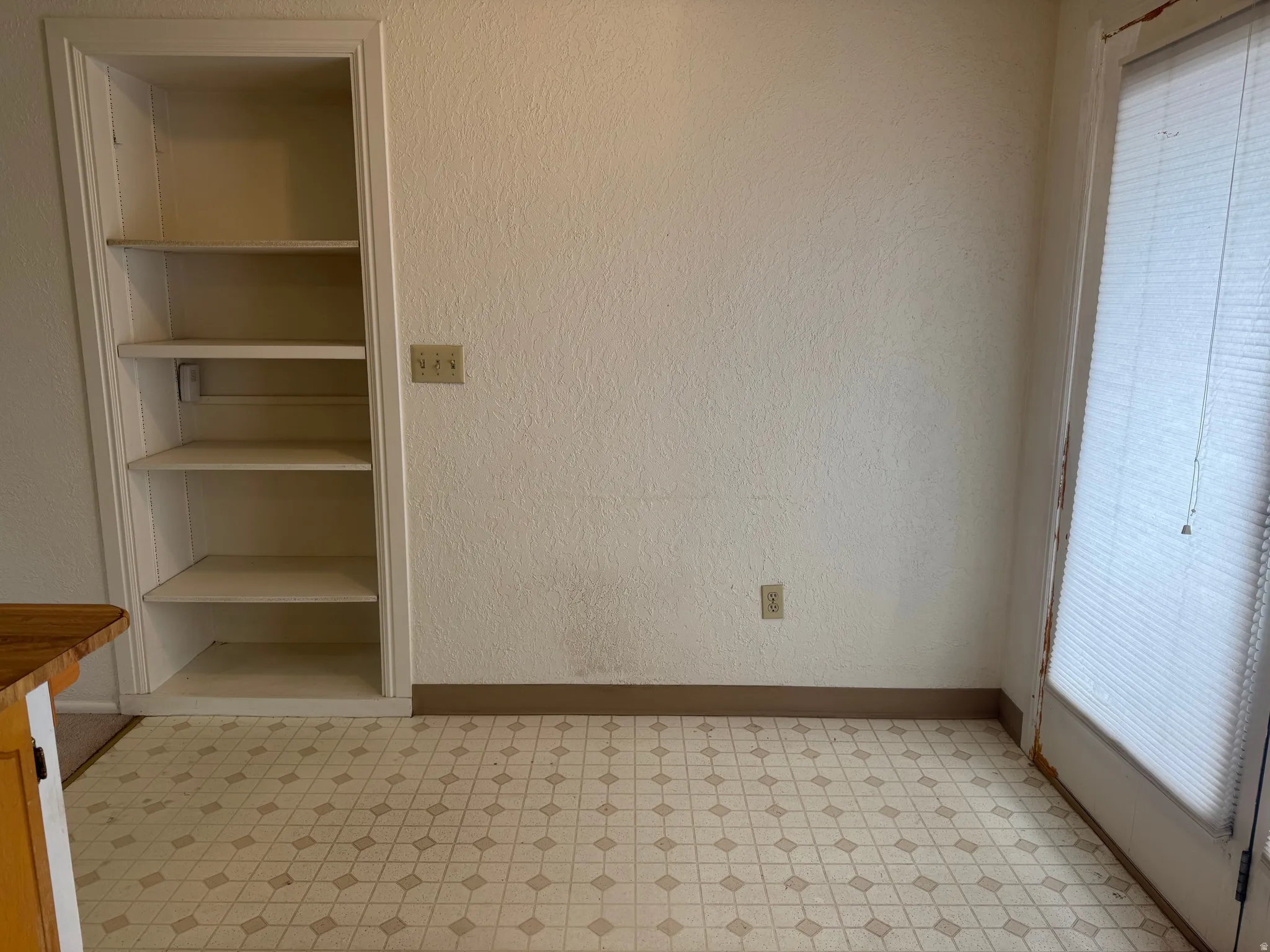 Unfurnished bedroom with light flooring and a textured wall