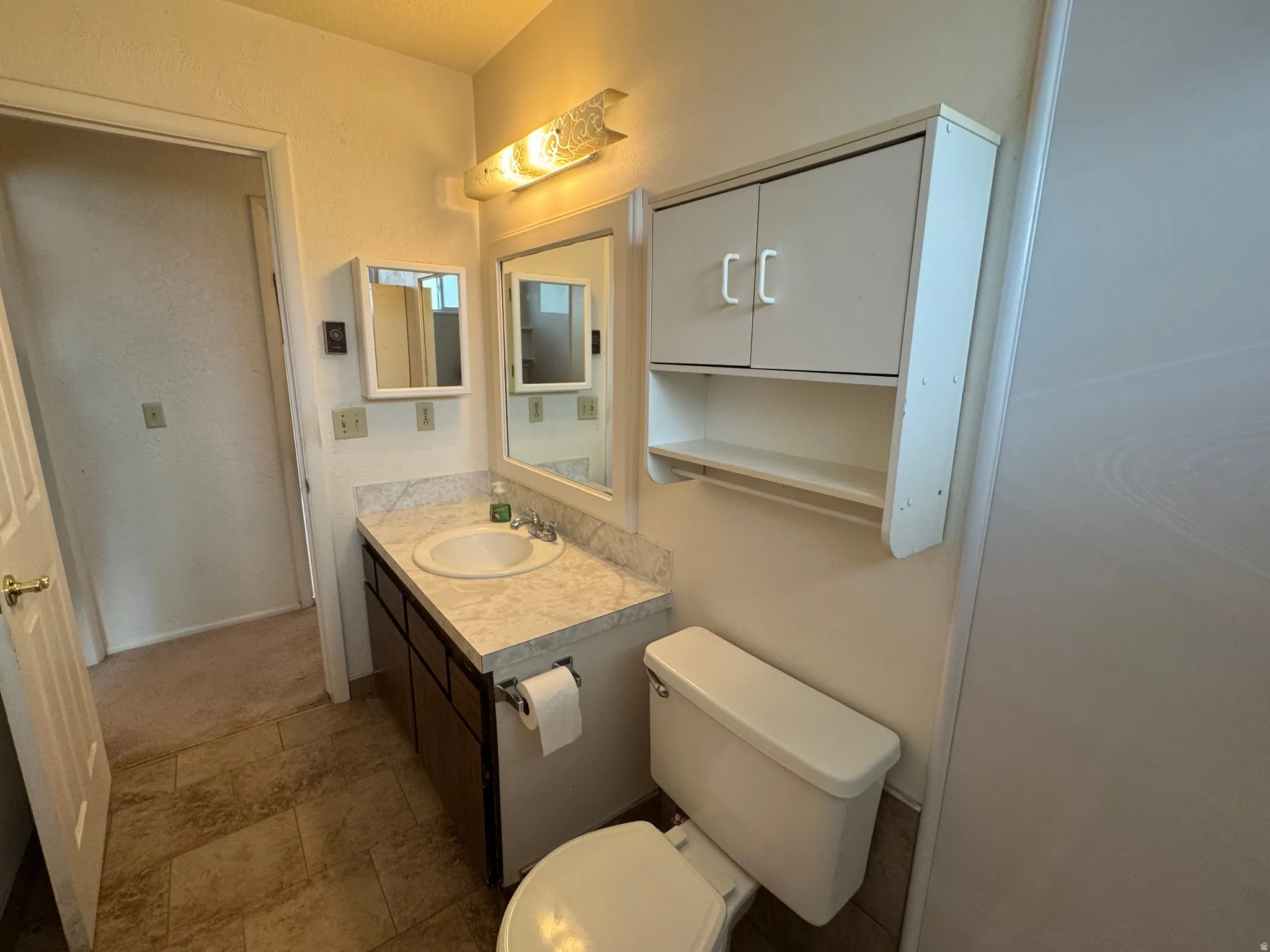 Bathroom featuring vanity and a textured wall