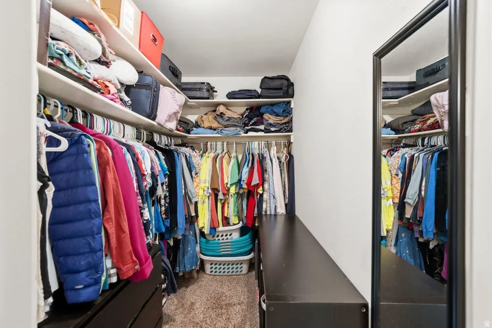 Walk in closet featuring dark carpet