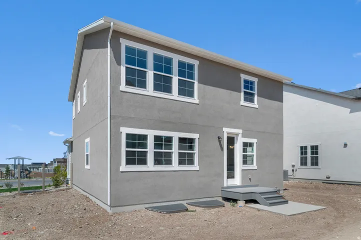 Two-story stucco exterior with white trim and multiple windows