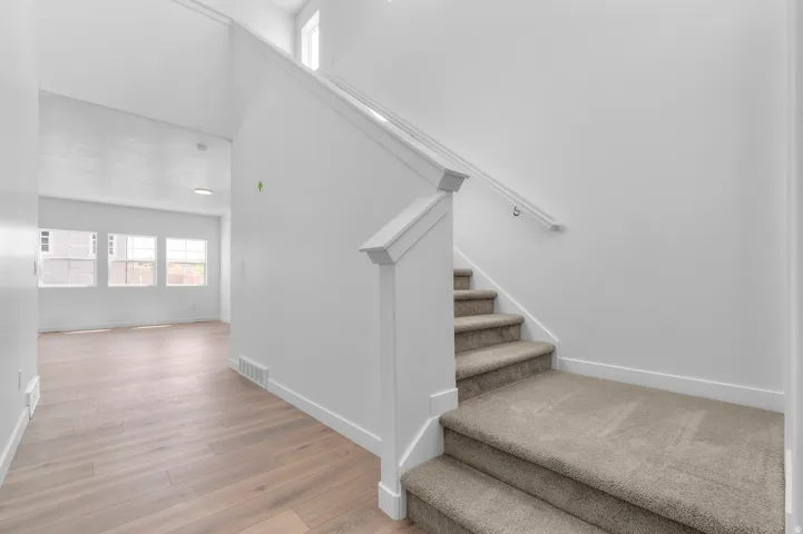 Carpeted staircase with white balustrade and handrail
