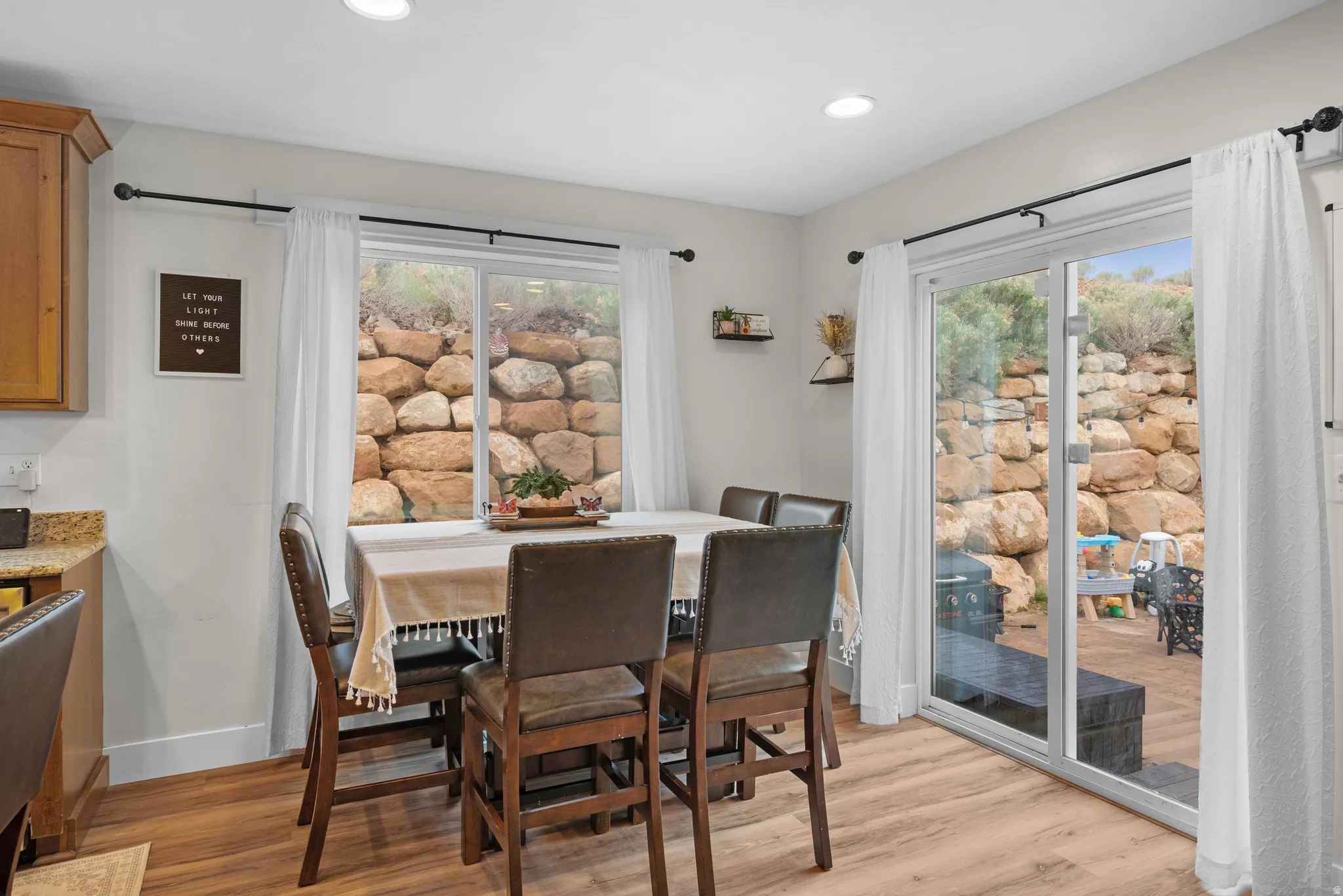 Dining room with light wood finished floors and recessed lighting