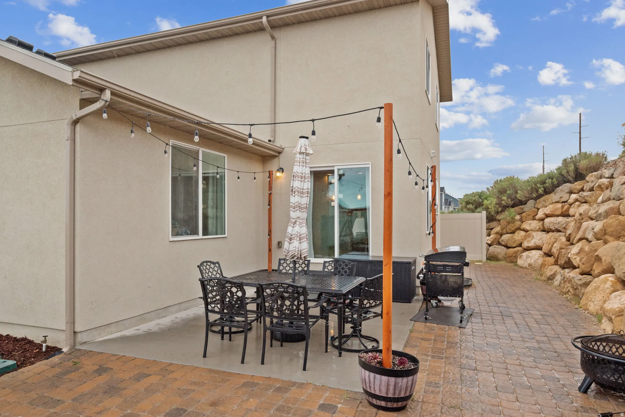 View of patio with outdoor dining area, grilling area, and a fire pit