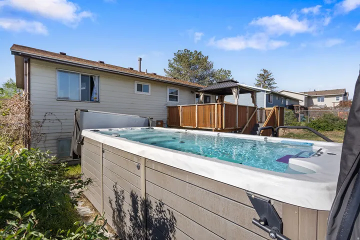 Outdoor swim spa with integrated jets, adjacent to a wood deck
