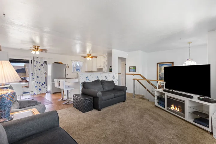 Open-concept living area featuring plush carpet flooring and white walls