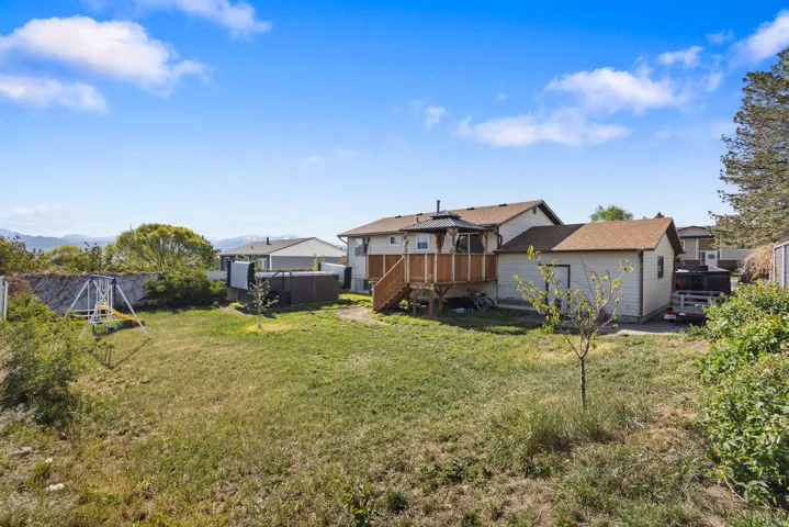 Expansive backyard featuring a deck and a swing set
