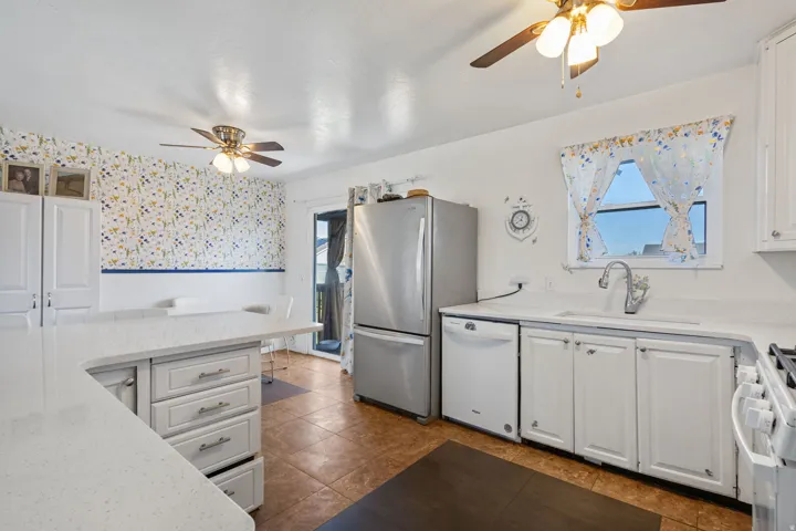 Kitchen featuring white cabinetry, light countertops, and tile flooring