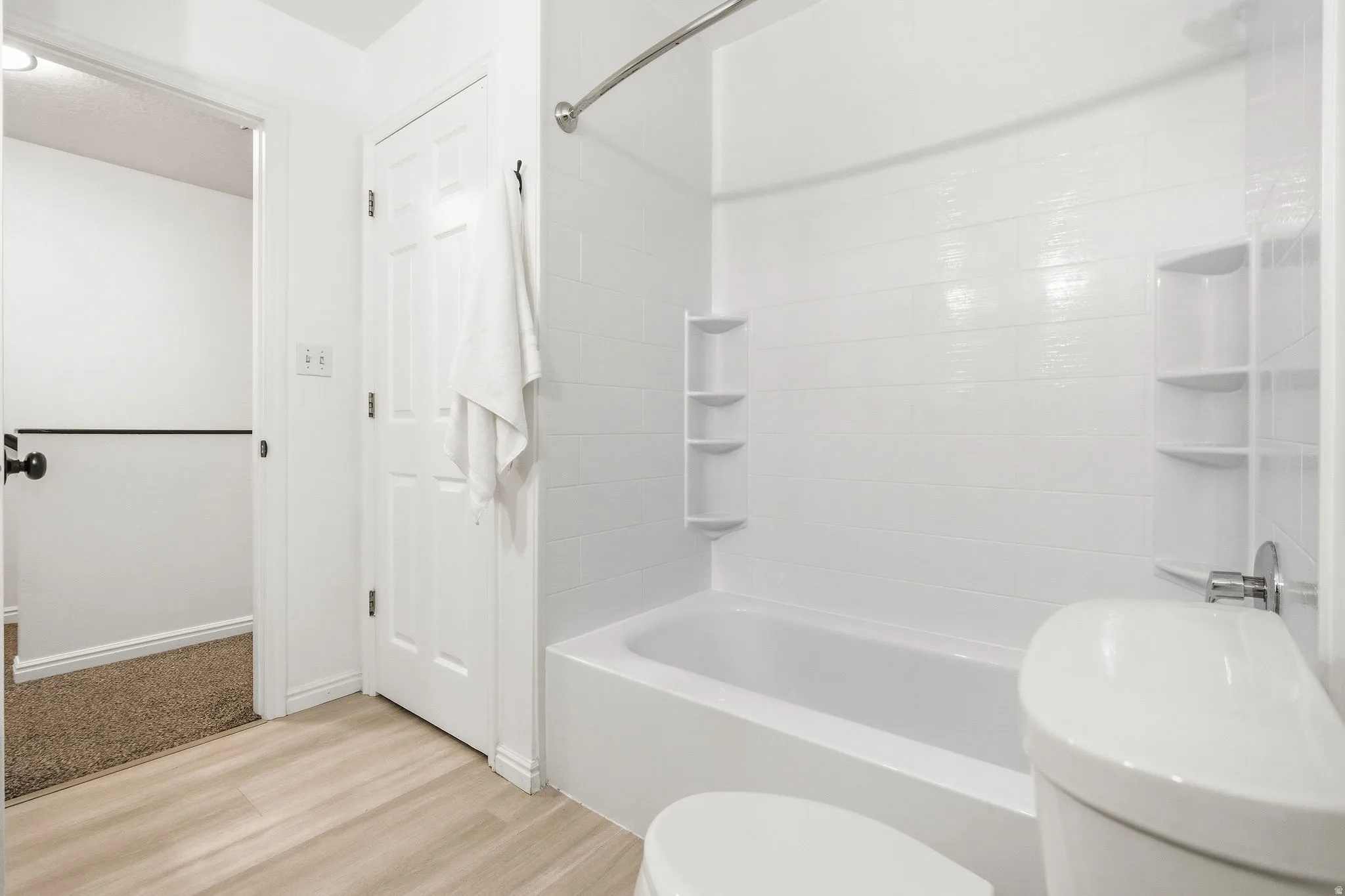 Full bathroom with shower / tub combination and light wood-style flooring