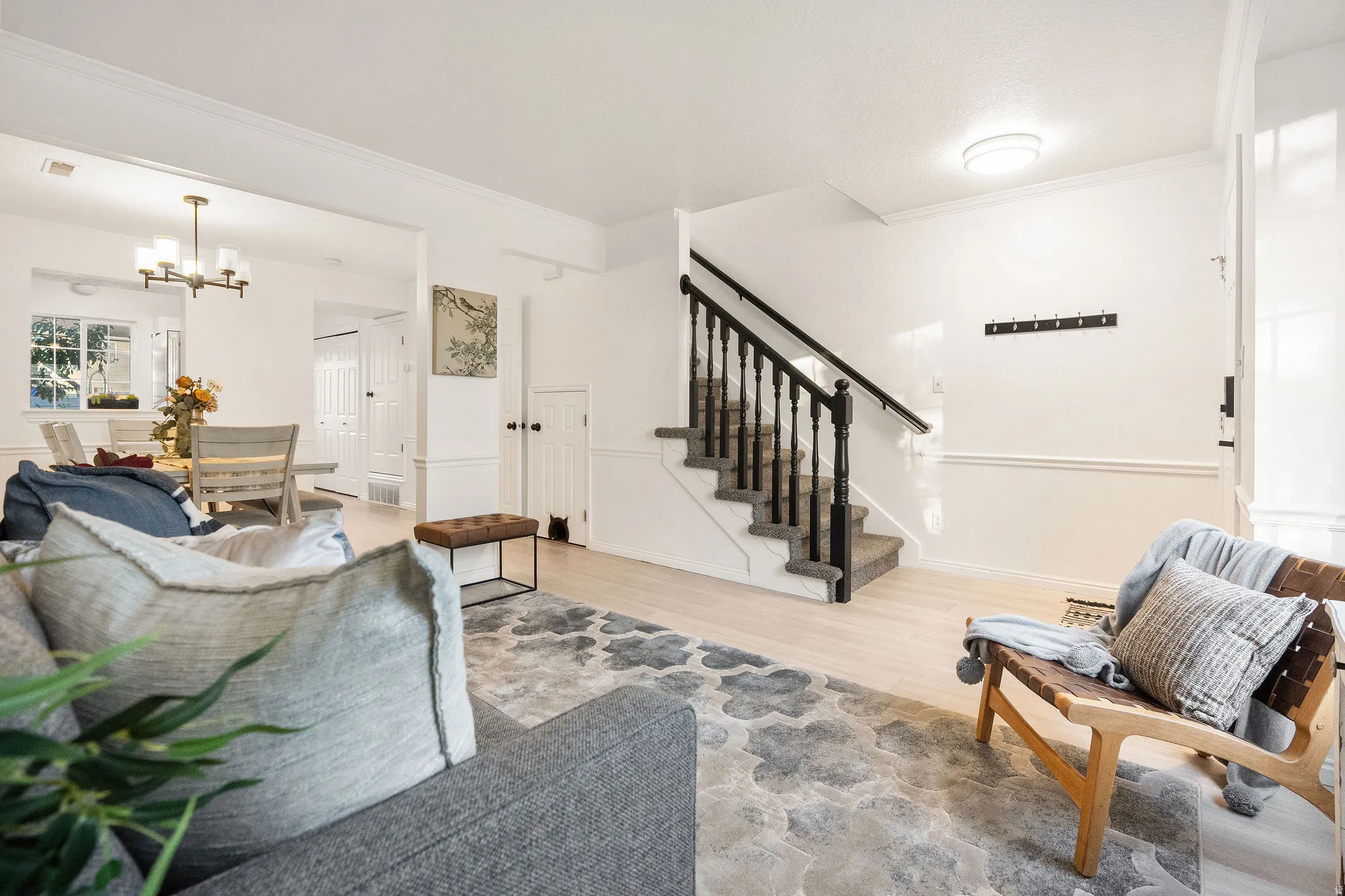 Living area featuring a chandelier, wood finished floors, and ornamental molding