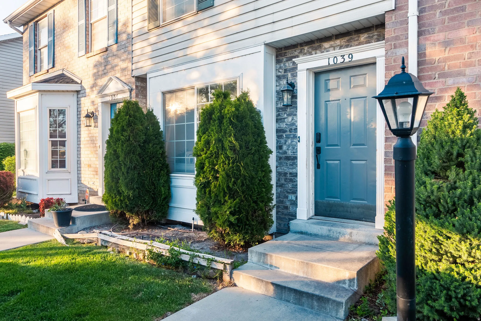 Entrance to property with stone siding and a lawn
