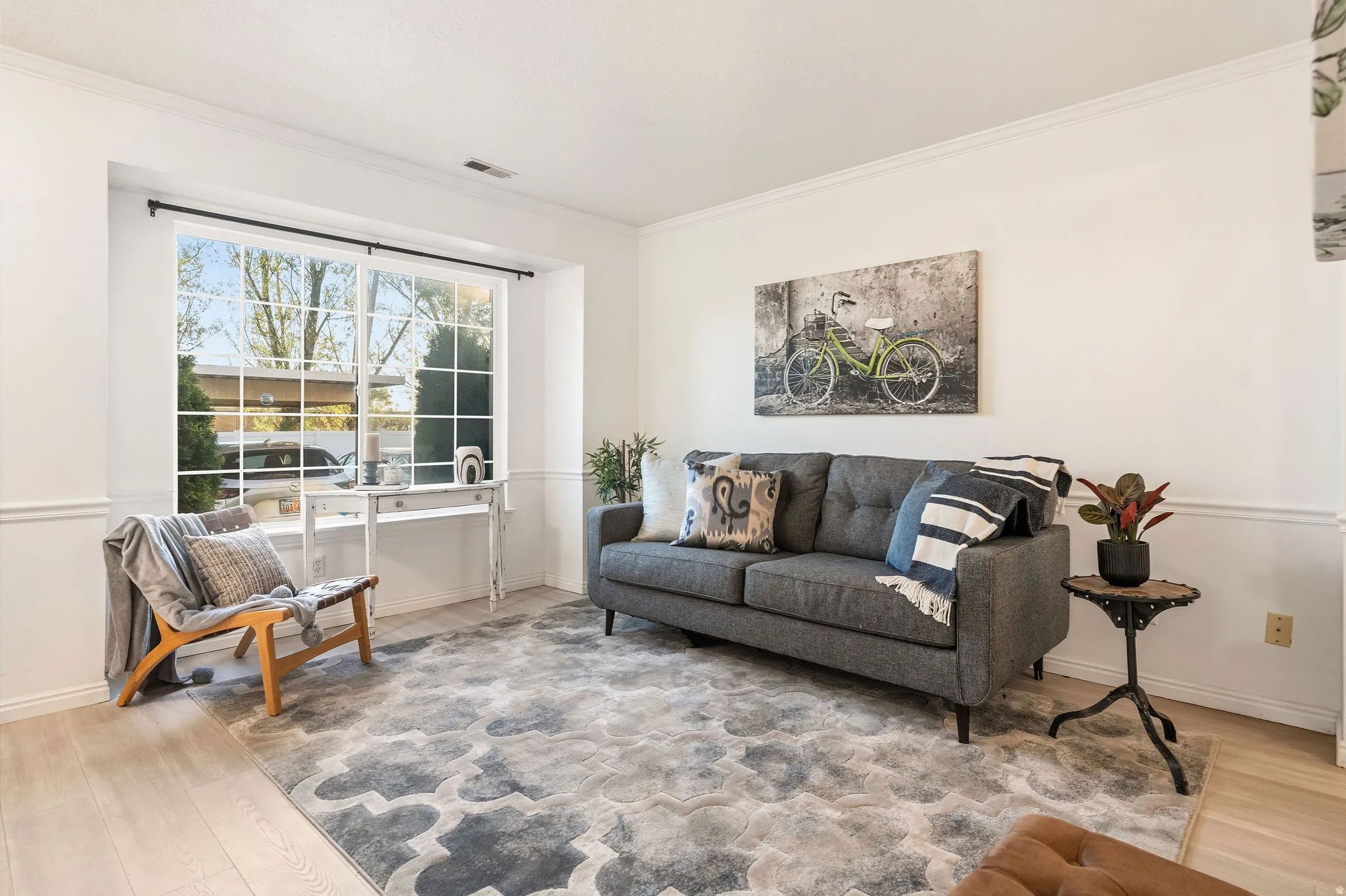 Living room featuring crown molding and light wood-style floors