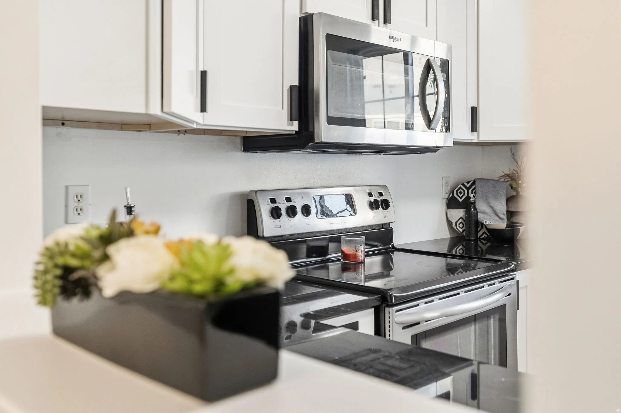 Kitchen featuring stainless steel appliances and white cabinetry