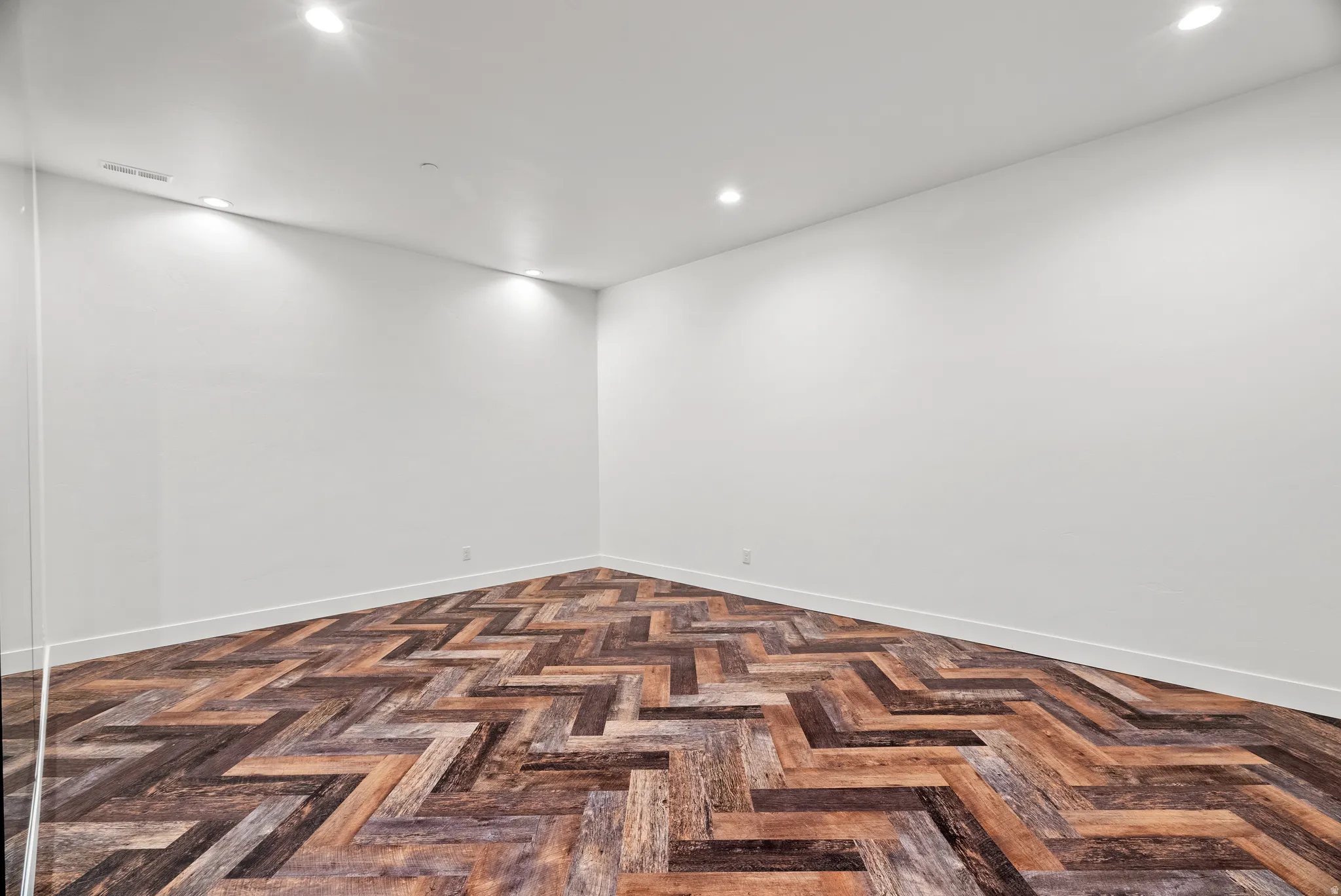 Spare room featuring recessed lighting and parquet floors
