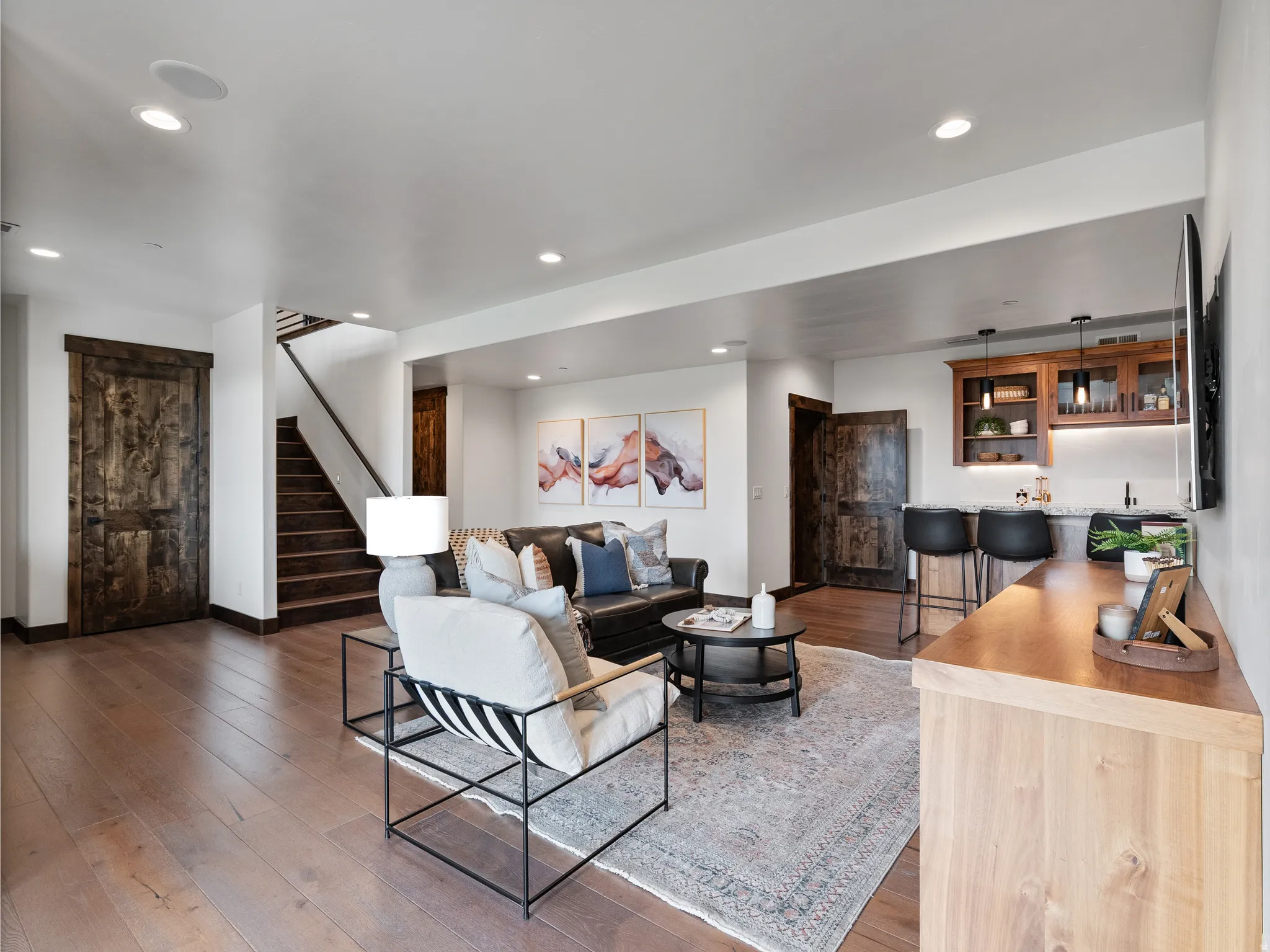 Living area featuring bar with sink, light wood-style flooring, and recessed lighting